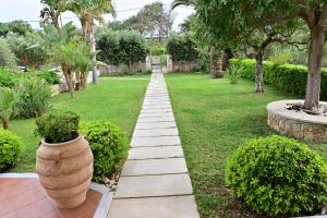 un jardín con un camino de piedra y un jarrón grande en Elia Seaside Villa, Amazing 2-Story Eco Pool House! en Kissamos