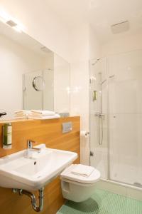a bathroom with a sink and a toilet and a shower at Hotel Johann in Berlin