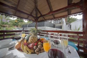a table with a bowl of fruit and glasses of wine at Royal Majestic Grand Thai Villa in Choeng Mon Beach