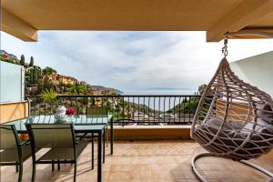 a balcony with a hammock and a table and chairs at COCO SUNSHINE Apartment TAORMINA in Taormina
