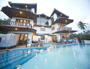 a house with a swimming pool in front of a house at Royal Majestic Grand Thai Villa in Choeng Mon Beach