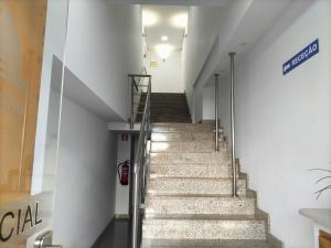 een trap in een gebouw met een bord aan de muur bij Residencial Tropicália AL in Praia da Barra