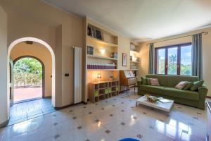uma sala de estar com um sofá verde e uma mesa em Villa Joy 6, Emma Villas em Foiano della Chiana