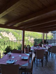 um restaurante com mesas e cadeiras e uma varanda em Agriturismo Orrido di Pino em Agerola