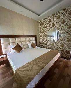 een slaapkamer met een groot bed en een spiegel bij Jungle Fowl Resort in Dehradun
