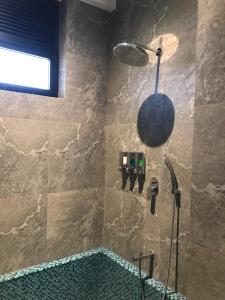 a bathroom with a tub and a shower with a shower head at Thimbiri Wewa Resort Wilpattu in Wilpattu