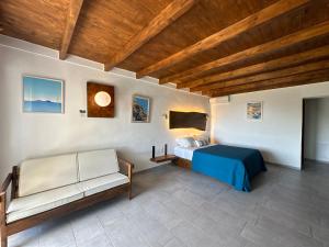 een slaapkamer met een bed en een bank in een kamer bij Galini Tropica in Agia Galini