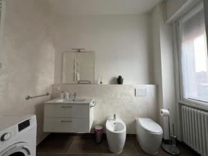 bagno bianco con servizi igienici e lavandino di Brunello Apartment a Mantova