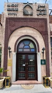 drzwi do budynku z znakiem powyżej w obiekcie Al Koot Heritage Hotel w mieście Al-Hufuf