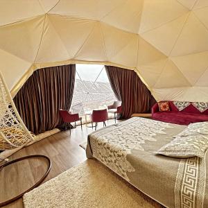a bedroom with a tent with a bed and chairs at Asman Glamping in Karakol +19 photos