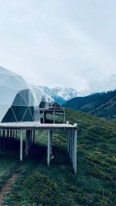 a couple of domes sitting on top of a hill at Asman Glamping in Karakol