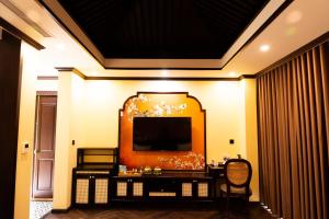 Legacy Hill Resort & Villas في Hòa Bình: غرفة معيشة فيها تلفزيون على جدار