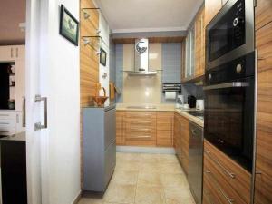 eine Küche mit Holzschränken und einem schwarzen Gerät in der Unterkunft Casa Géminis in Playa Honda + 30 Fotos