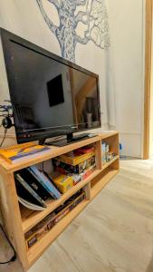 a flat screen tv on a wooden entertainment center at Au bon endroit -- Chambre chez l'habitant -- Via Rhona 