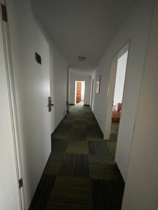un pasillo con paredes blancas y un largo piso con un pasillo en Ferienwohnung 4 Personen 1, en Rieden