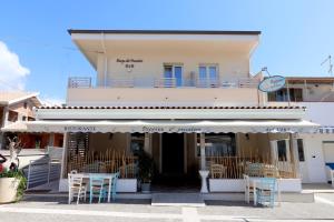 a building with tables and chairs in front of it at Borgo dei Pescatori - SUL MARE in Capo Vaticano