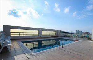 a swimming pool on the roof of a building at Super OYO Capital O 111 Infinity Suites in Manama