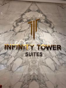 eine Marmorwand mit dem Schild der Infinity-Turm-Suiten in der Unterkunft Super OYO Capital O 111 Infinity Suites in Manama