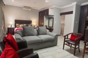 a living room with a couch and a bed at InnJoy Boutique Hotel in Centurion