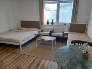 a living room with two beds and a table at Apartament KLEMENS nr domu 14 in Ostrów Wielkopolski