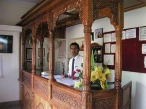 un hombre sentado en un mostrador con un espejo en Hotel Golden City with Swimming Pool, en Jaisalmer