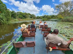 a group of people riding a boat down a river at Falaza Game Park and Spa in Hluhluwe