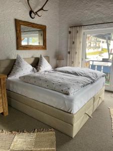 un letto grande in una camera da letto con finestra di Traum Fewo Hindelang a Bad Hindelang