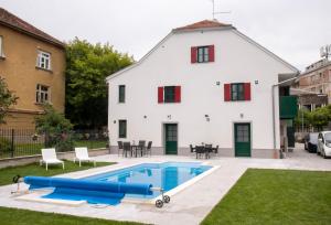a house with a swimming pool in front of it at Apartman Vili in Zagreb
