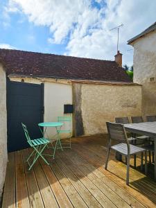 a patio with a table and chairs on a deck at Le gite du Maréchal in Saint-Aignan