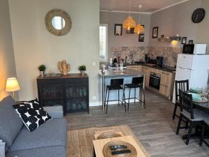 un soggiorno e una cucina con un divano e un tavolo di Belle maison médocaine a Saint-Julien-Beychevelle Altre 13 foto