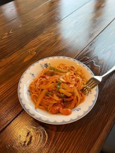 a bowl of spaghetti with a fork on a wooden table at Populus-club Otaru - Vacation STAY 91869v in Otaru