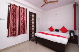 a bedroom with a large bed with red pillows at Four Seasons in Sikandra