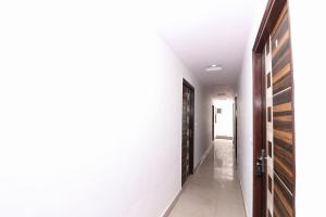 un pasillo con paredes blancas y puertas de madera en Four Seasons en Sikandra