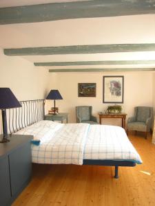 a bedroom with a bed with two chairs and two lamps at Apartmenthaus Brunnenhof in Papstdorf