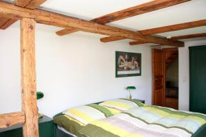 a bedroom with a bed and wooden beams at Apartmenthaus Brunnenhof in Papstdorf