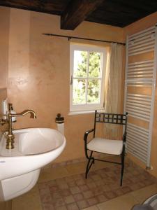 een badkamer met een wastafel, een stoel en een raam bij Apartmenthaus Brunnenhof in Papstdorf