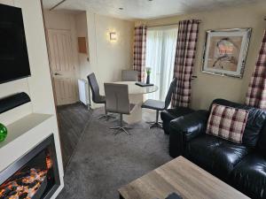 a living room with a couch and a table with a fireplace at Tudor Lodge Hotel in Nottingham