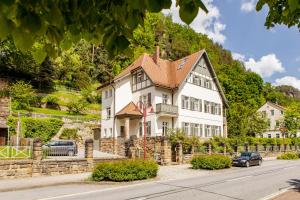 ein großes weißes Haus mit braunem Dach in der Unterkunft Villa Elbufer in Bad Schandau