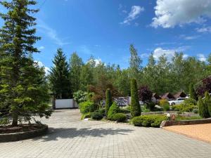 a garden with trees and bushes on a sidewalk at Hotel Zoloti Vorota in Lalovo