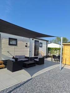 a patio with a black awning on a caravan at Beach Resort Nieuwvliet Bad - NV 37 in Nieuwvliet