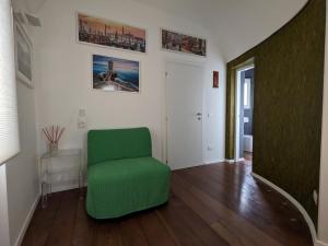 una sala de estar con una silla verde en una habitación en Tophouse Centuripe Centro, en Centuripe