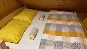 1 cama con 2 almohadas y 1 manta en Velika planina Chalet SLOVENKA en Stahovica