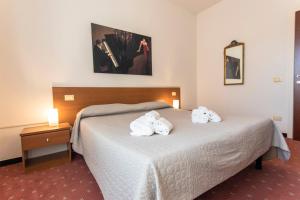 Una habitación de hotel con una cama con toallas. en Hotel Moranna en Lido di Camaiore