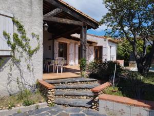 ein Haus mit einem Steinweg, der auf eine Veranda führt in der Unterkunft Maison de vacances avec piscine et jardin in Bompas