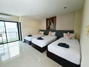 a bedroom with two beds with white sheets at STAYHERE@AIRPORT SERVICE APARTMENT in Ban Bo Han
