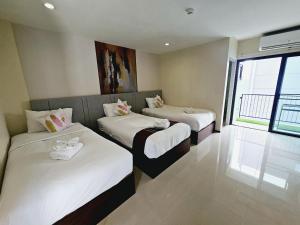 a room with two beds with white sheets at STAYHERE@AIRPORT SERVICE APARTMENT in Ban Bo Han
