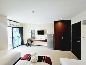 a room with two beds and a desk and a kitchen at STAYHERE@AIRPORT SERVICE APARTMENT in Ban Bo Han