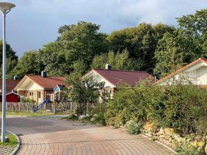 a row of houses with a fence and a driveway at Feriendorf Südstrand Haus 40 in Pelzerhaken