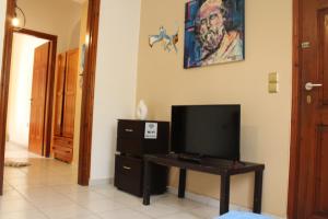 a living room with a tv and a table with a television at Rodi Apartment 2 in Kamari