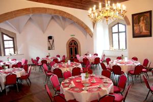 a room with tables and chairs and a chandelier at Schloss Hotel Wurzen in Wurzen